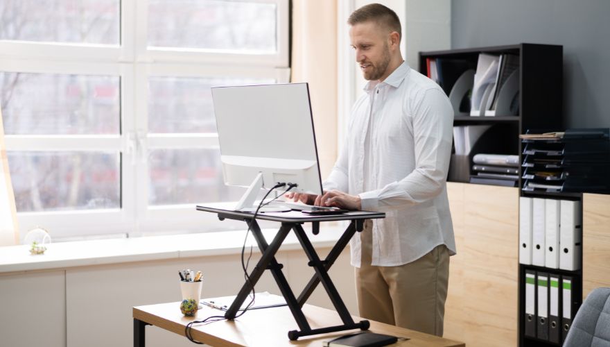a man using a standing desk riser